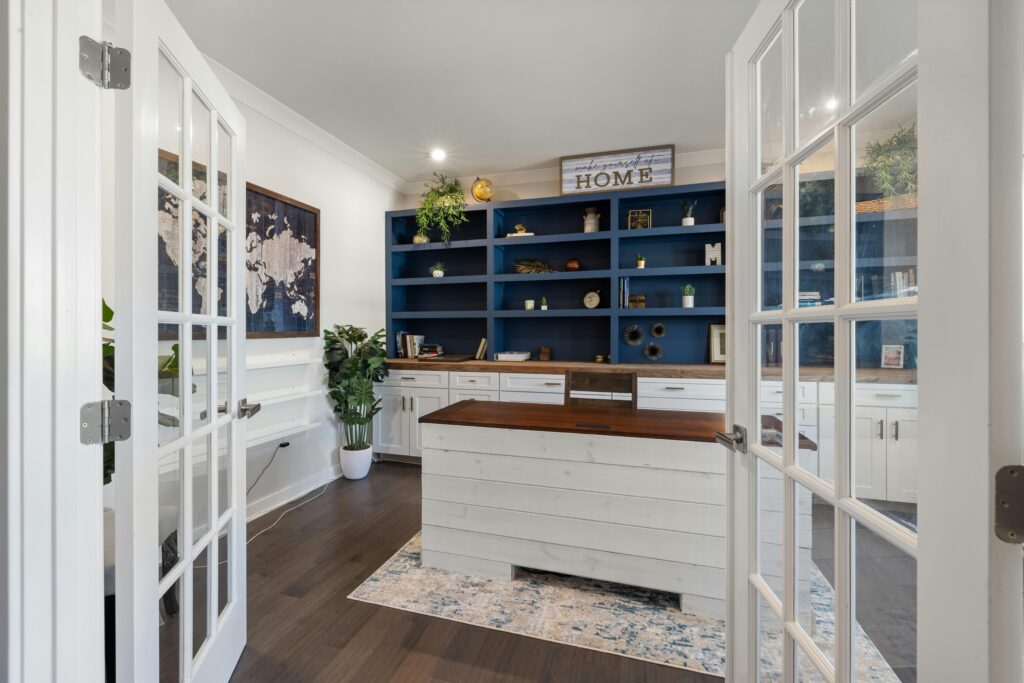 Bright and stylish home office with blue shelves and white desk, perfect for productivity.